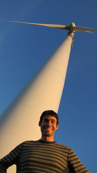 a man stands at the base of a windmill in Minnesota