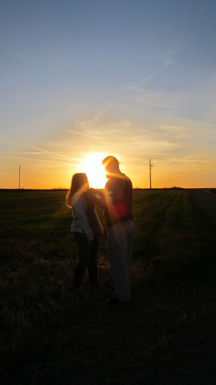 a couple at sunset on a windfarm